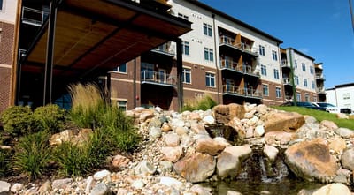 Exterior view of Woodlands Creek Senior Living with landscaping