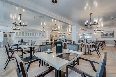 Bright dining area with elegant seating and chandeliers