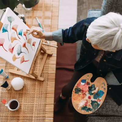 Resident painting at an easel in a cozy setting