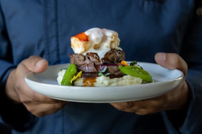 A chef presenting a gourmet plate of food