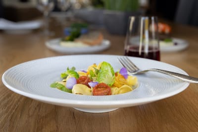 Plate of gourmet pasta with vegetables and garnish