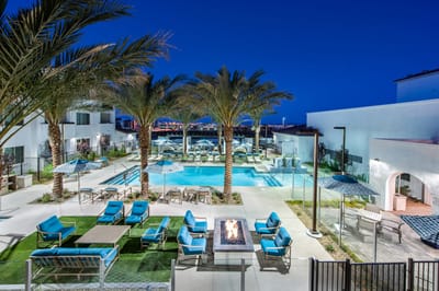 Outdoor pool area with lounge chairs and palm trees