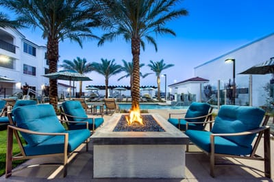 Outdoor fire pit area with seating and palm trees