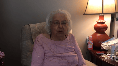 A senior resident sitting in a cozy chair