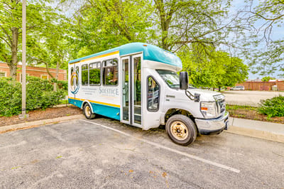 Facility transport van parked outside among trees