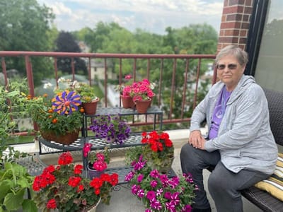 Resident enjoying flowers on a balcony terrace