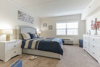 A well-decorated resident room with a bed and furniture