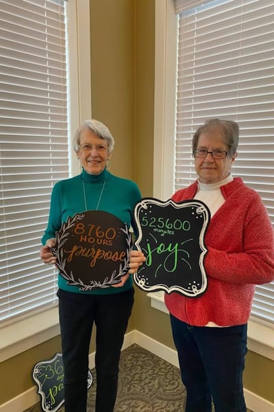 Two residents holding chalkboards with motivational messages