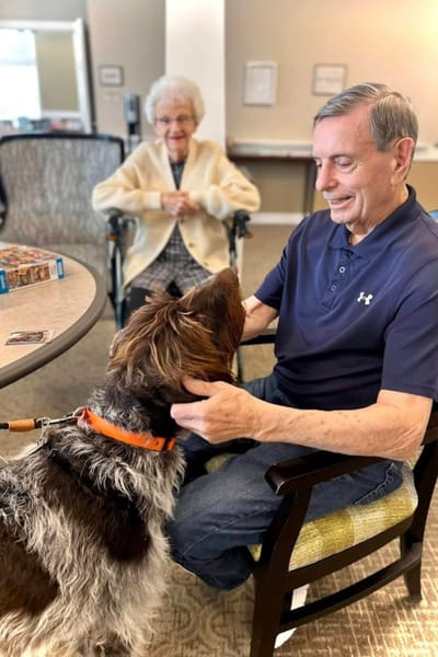 Residents interacting with a dog in a common area