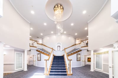 Elegant lobby featuring a grand staircase and chandelier