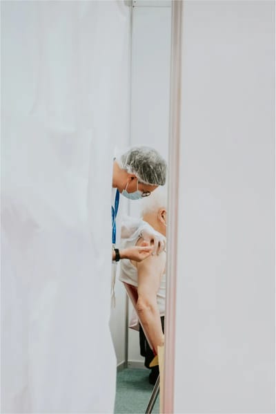 A healthcare worker administering a vaccine to a senior