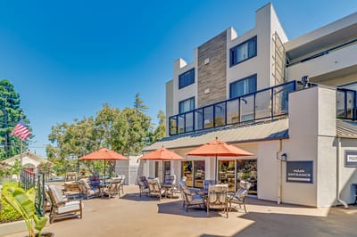 Exterior view of a senior living facility with outdoor seating