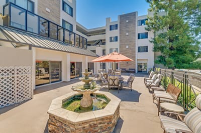 Outdoor seating area with a fountain and building in the background