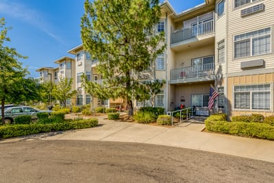 Exterior view of a senior living facility with landscaped entrance