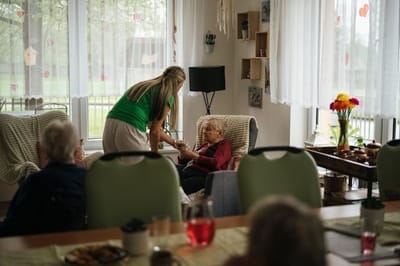Staff member assisting a resident in a cozy lounge area