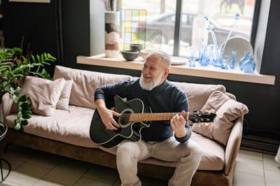 Resident playing guitar in a common area