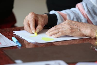 Close-up of an elderly person's hand coloring