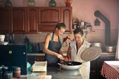 Two people cooking in a cozy kitchen environment