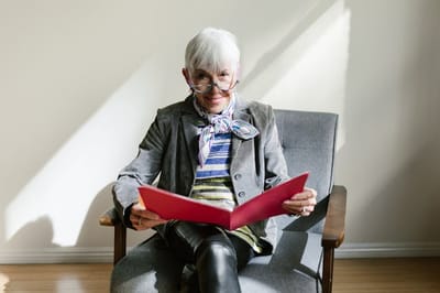 Senior woman reading a book in a cozy chair