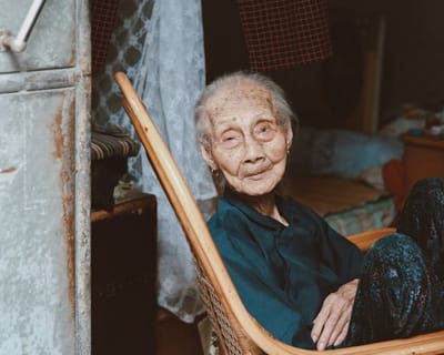An elderly woman sitting in a chair indoors