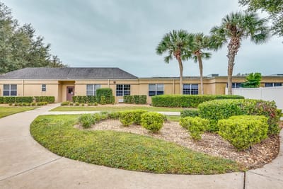 Outdoor pathway with landscaped gardens and palm trees