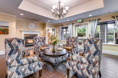 Common area in a senior living facility with a fireplace and seating
