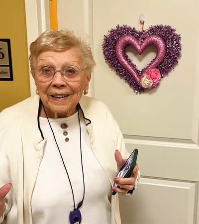 Resident smiling in front of a decorated door