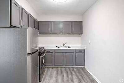 Modern kitchen area with gray cabinets and appliances