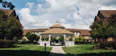 Outdoor gazebo surrounded by greenery and buildings