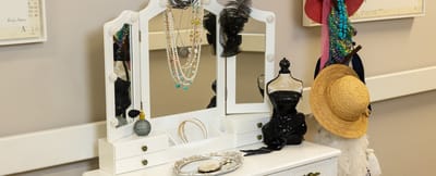 Decorative dresser with jewelry and hats in a common area