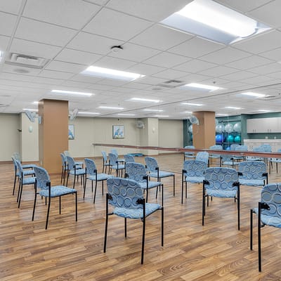 Well-lit activity room with empty chairs arranged