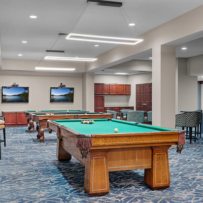 Bright activity room with pool tables and seating