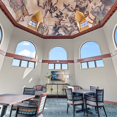 Bright common area with artistic ceiling and large windows