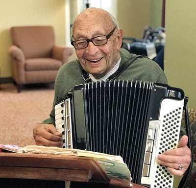 Resident playing accordion in a common area