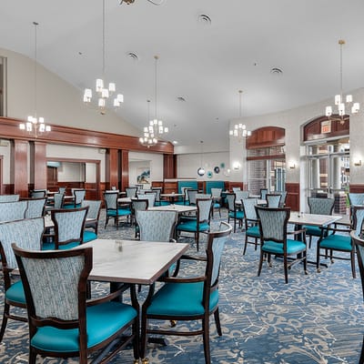 Dining room with teal chairs and elegant lighting