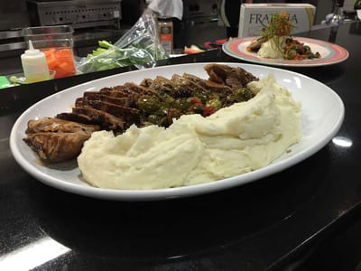 A plate of sliced chicken with mashed potatoes
