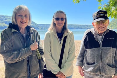 Three residents enjoying a sunny outdoor moment by the lake