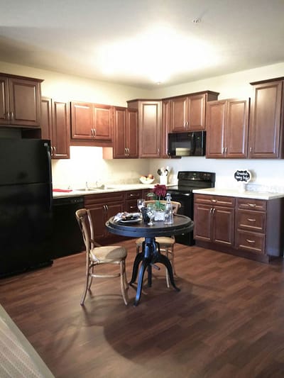 A cozy kitchen area with wooden cabinets and a table