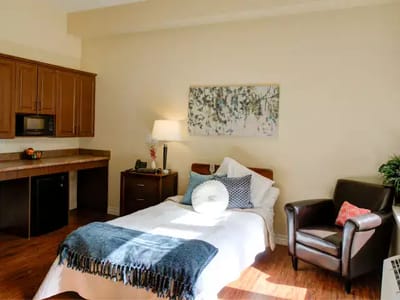 Bright, cozy resident room with a bed and amenities