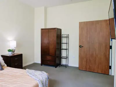 A private resident room with a bed and wardrobe