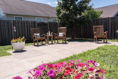 Outdoor patio area with rocking chairs and flowers