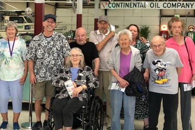 Group of residents and staff smiling together indoors