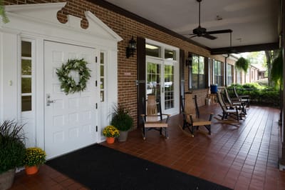 Front entrance of a senior living facility with rocking chairs
