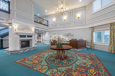 Bright lobby area with decorative carpet and fireplace
