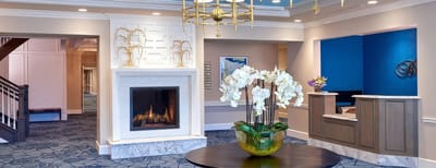 Welcoming lobby area with a fireplace and floral arrangement