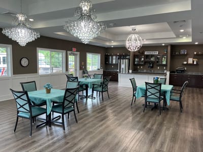Bright common area with tables and chandeliers