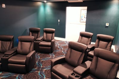 Interior view of a cozy movie room with recliners