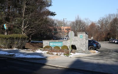Entrance sign of a senior care facility with surrounding landscape