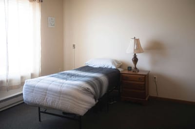 Cozy private resident room with a bed and lamp