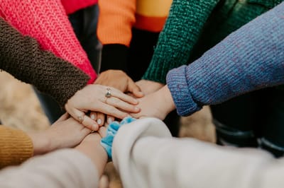 A group of hands together in a circle showing unity